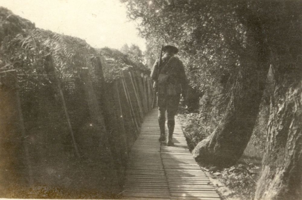 A soldier walks along Willow Walk, a communication trench near Armentières, Belgium, 1916.